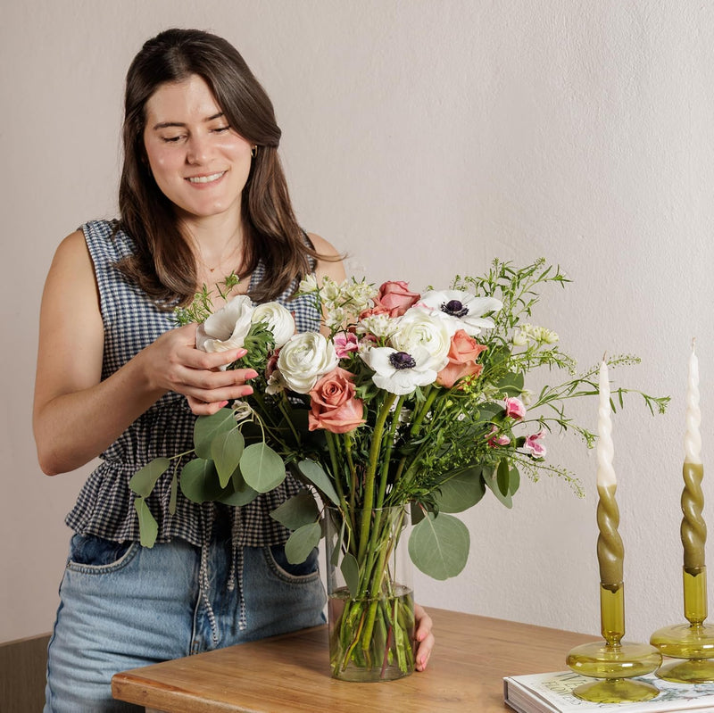 Woman holding a hand-tied bouquet of Ecuadorian roses and anemones