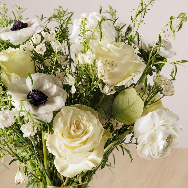 White sympathy bouquet with roses and anemones