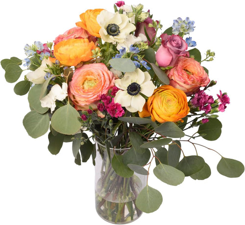 The Sweetheart Bouquet with ranunculus and peach roses in a glass vase