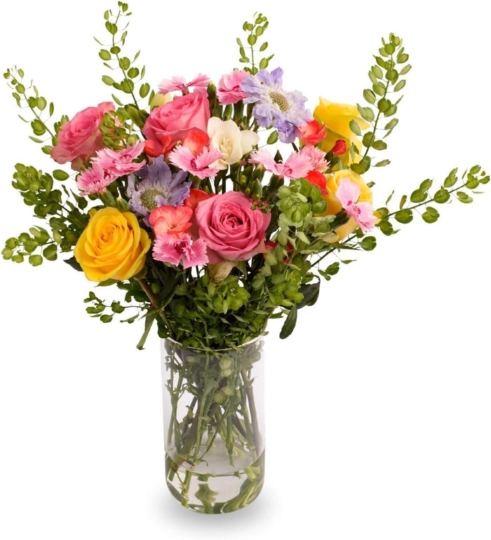 Enchanted Blooms bouquet with yellow roses and pink blooms in a glass vase