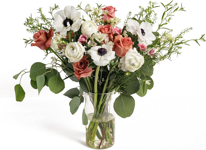 Terra Harmony bouquet with terracotta roses and white anemones in a glass vase