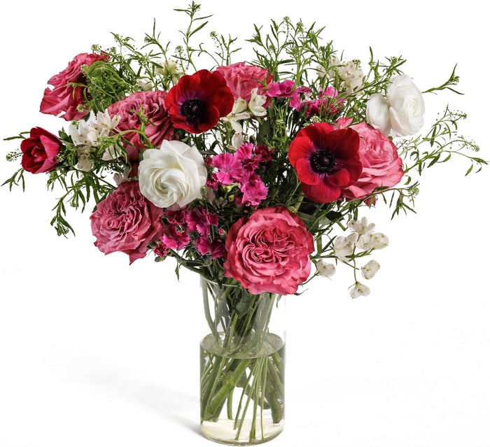 Symphony bouquet with red and pink roses and anemones in a glass vase